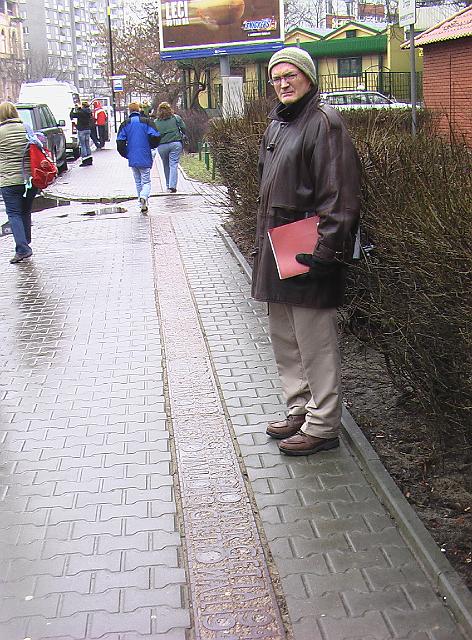 019.JPG - I'm standing inside where the Warsaw ghetto's wall was located.  You can see the memorial running down the present day sidewalk.